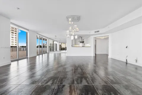 a view of a living room a kitchen and chandelier