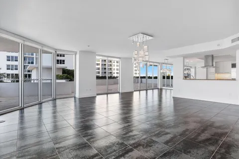 an empty room with wooden floor and large windows