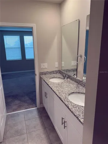 a bathroom with a granite countertop sink and a mirror