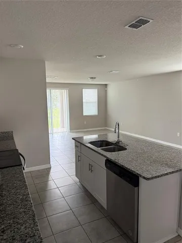 a kitchen with granite countertop a sink and a stove