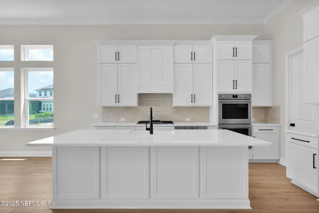 a kitchen with granite countertop white cabinets and stainless steel appliances