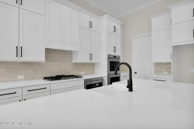 a kitchen with granite countertop white cabinets and appliances