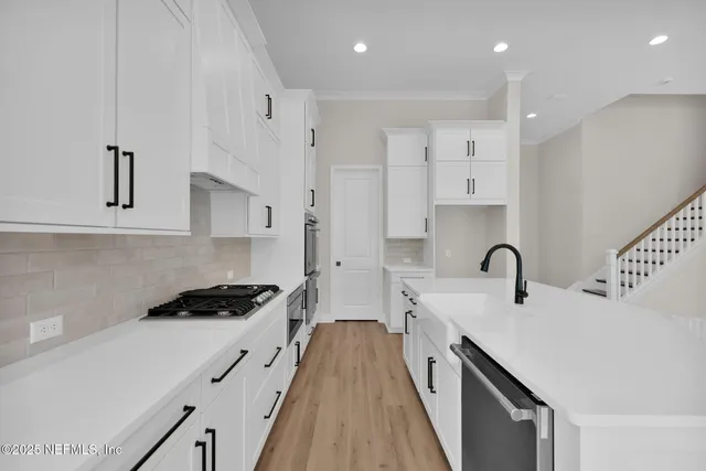 a kitchen with stainless steel appliances a sink stove and cabinets