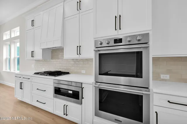 a stove top oven sitting inside of a kitchen