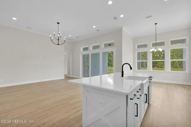 a view of a kitchen counter space with wooden floor and chandelier