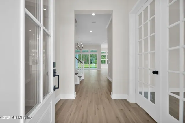 a view of a hallway with wooden floor and staircase