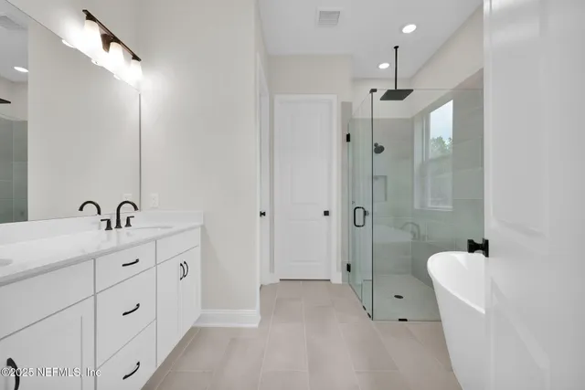 a bathroom with a tub sink and mirror