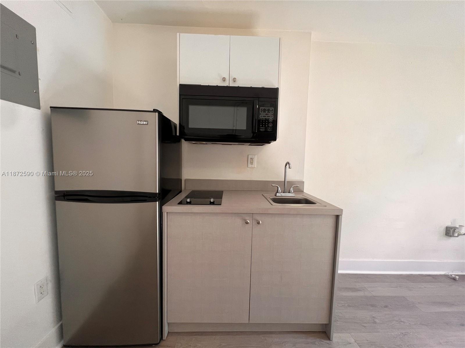 143 Southwest 9th Street, Unit 109 Miami, FL 33130 - Photo 4 of 5 a kitchen with stainless steel appliances a refrigerator and a microwave