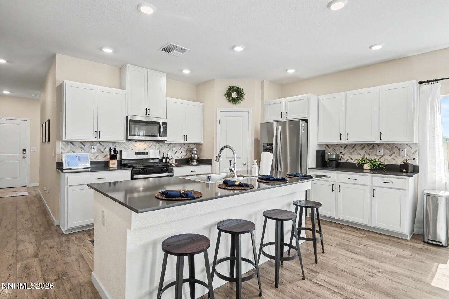 606 Sycamore Drive Fallon, NV 89406 - Photo 5 of 26 a kitchen with stainless steel appliances granite countertop a stove top oven a refrigerator a sink and white cabinets