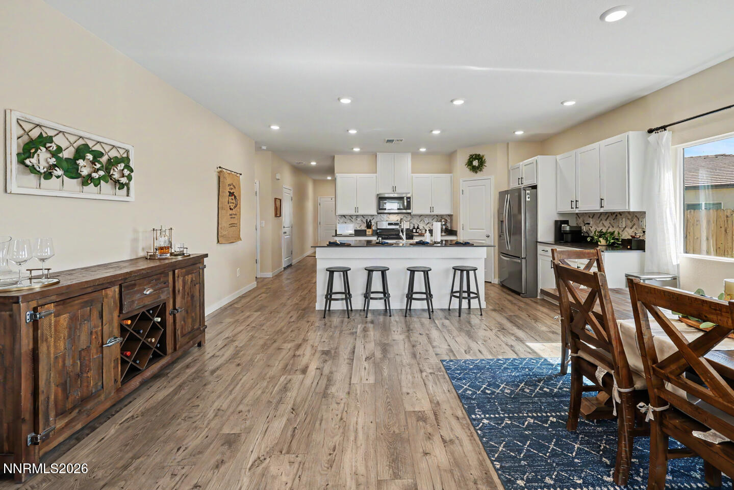 606 Sycamore Drive Fallon, NV 89406 - Photo 9 of 26 a kitchen with stainless steel appliances granite countertop a stove top oven a sink dishwasher and a dining table with wooden floor