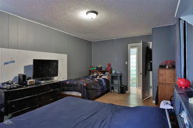 a living room with furniture a flat screen tv and a refrigerator