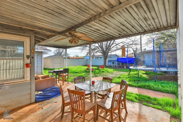 a patio with wooden table and chairs