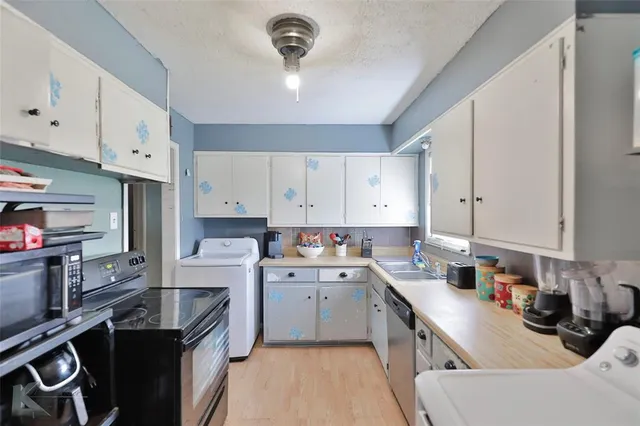 a kitchen with a sink stove and cabinets