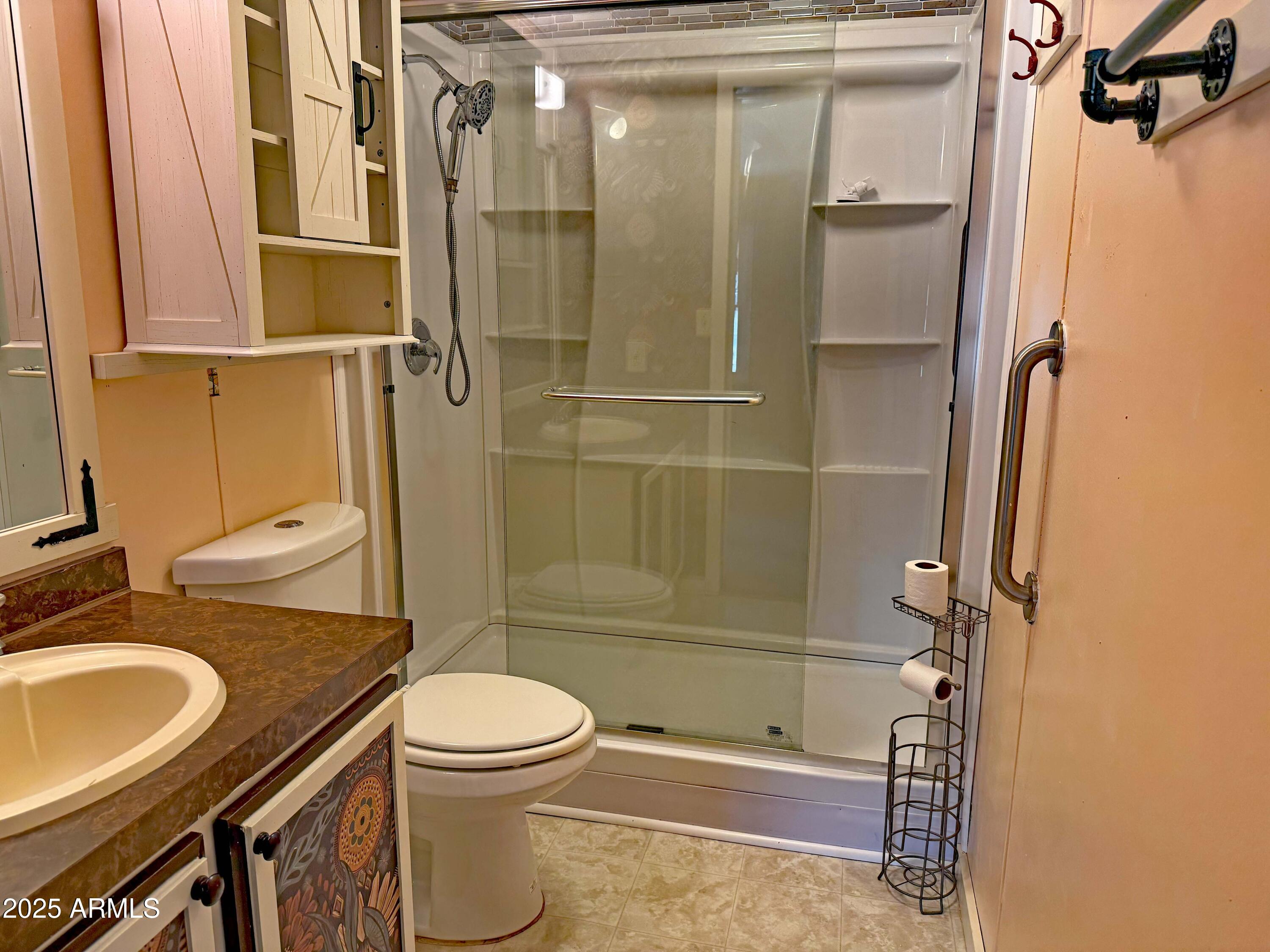4715 North Drifting Sands Road Rimrock, AZ 86335 - Photo 21 of 39 a bathroom with a granite countertop toilet sink and shower