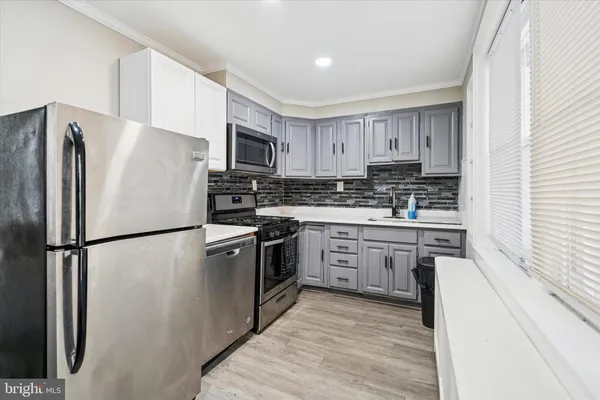 a kitchen with cabinets stainless steel appliances and a window
