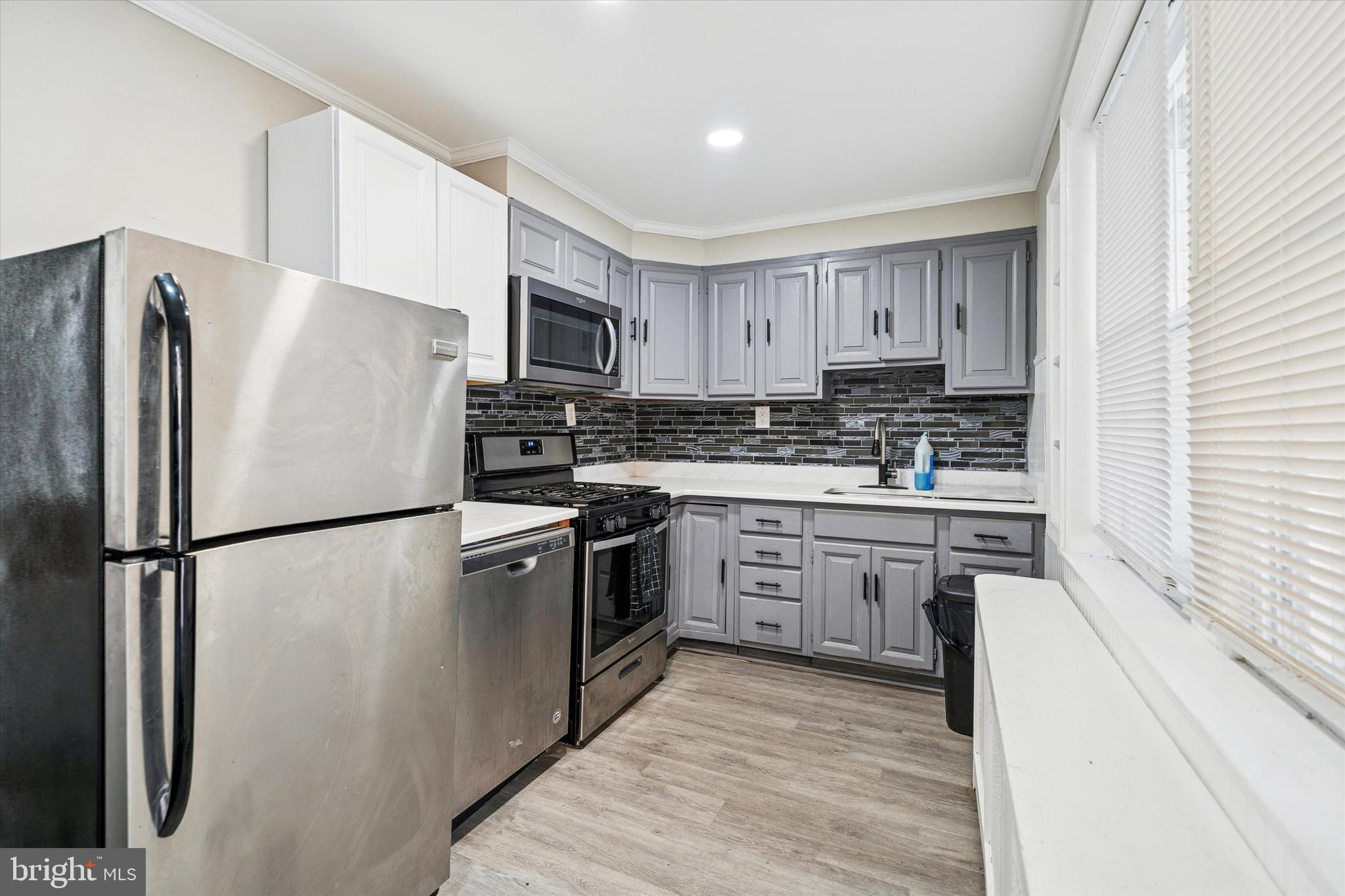 352 Carson Street Philadelphia, PA 19128 - Photo 12 of 35 a kitchen with cabinets stainless steel appliances and a window