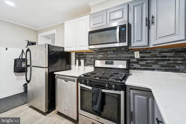 a kitchen with stainless steel appliances granite countertop a stove microwave and refrigerator