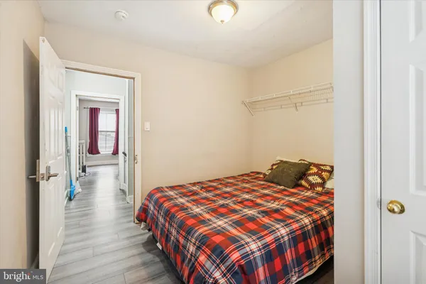 a bedroom with a bed and wooden floor