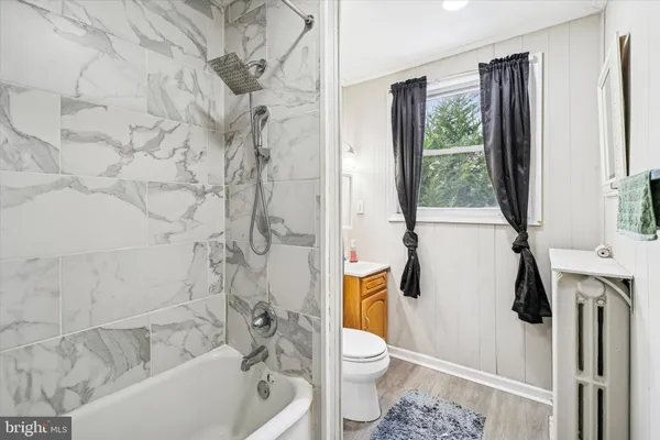 a white toilet sitting next to a bath tub and a shower