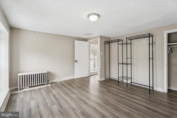 an empty room with wooden floor and a yard