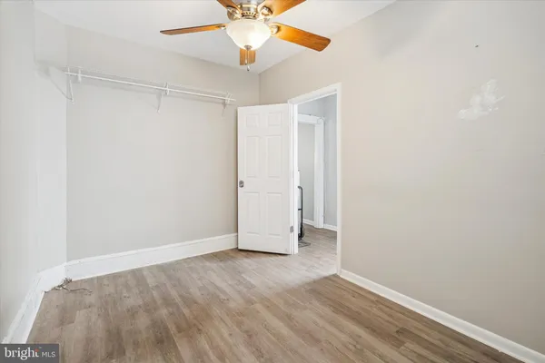 an empty room with a ceiling fan and wooden floor