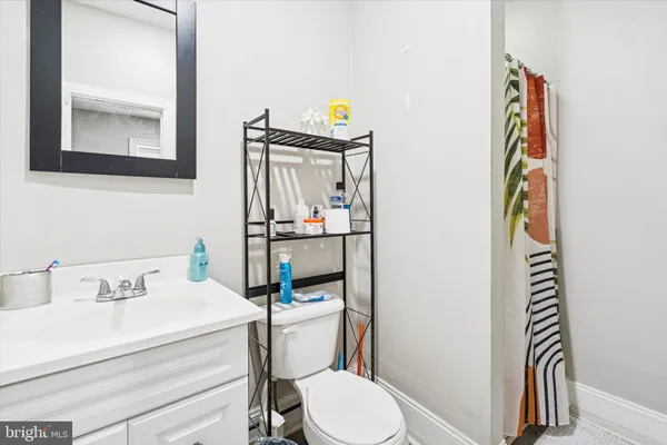 a bathroom with a sink toilet and mirror