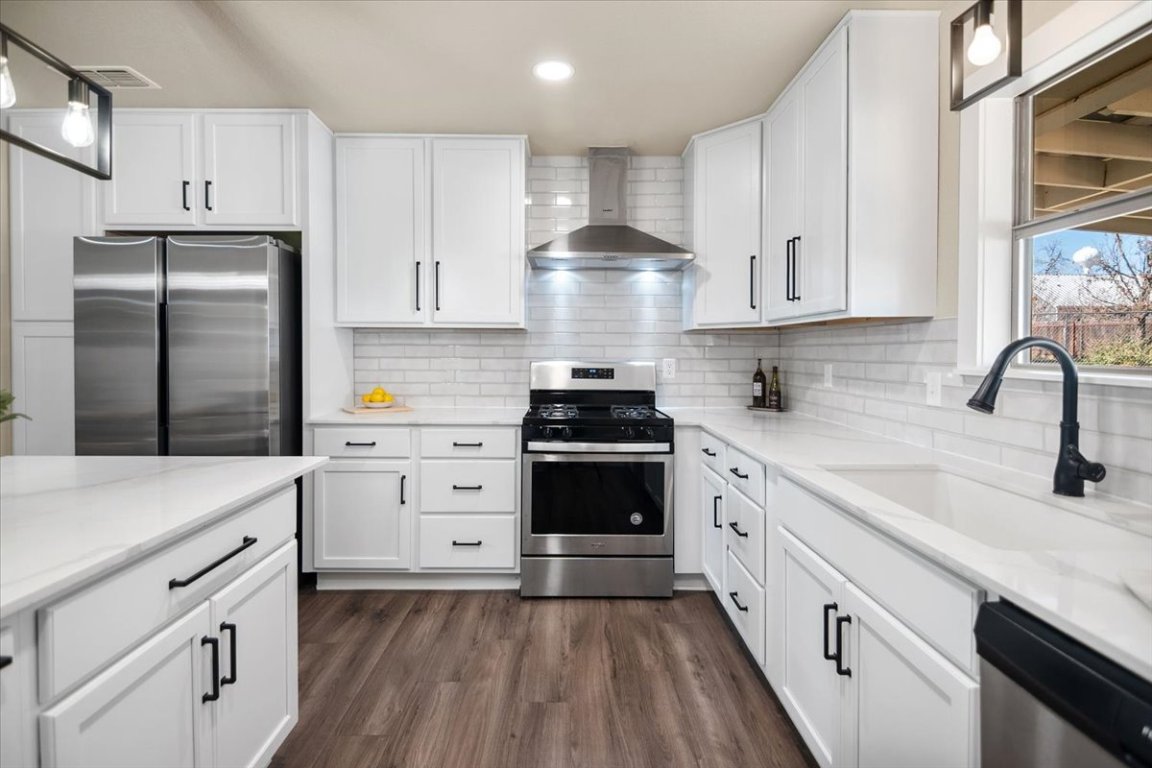 1236 Martin Street Mason, TX 76856 - Photo 11 of 40 a kitchen with cabinets stainless steel appliances a sink and wooden floor
