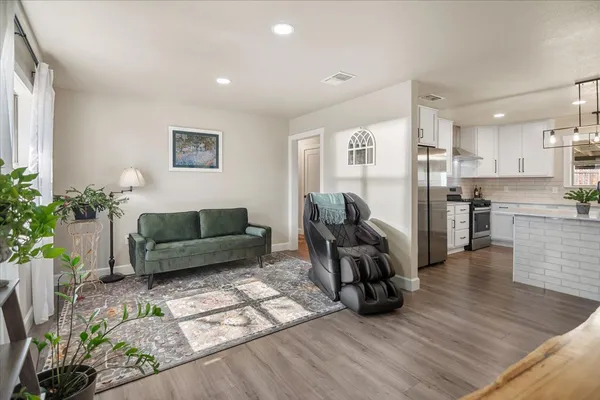 a living room with furniture and wooden floor