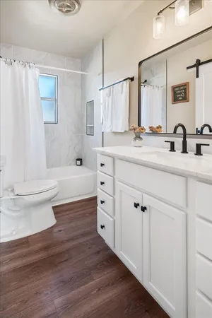 a bathroom with double vanity sink a mirror and a toilet