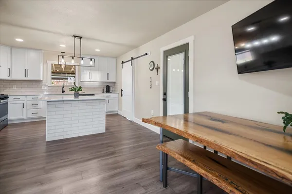 a kitchen with kitchen island white cabinets and stainless steel appliances