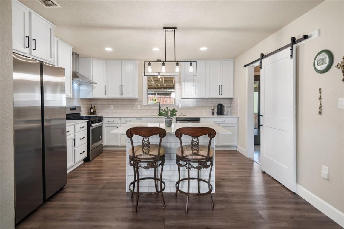 1236 Martin Street Mason, TX 76856 - Photo 7 of 40 a kitchen with stainless steel appliances a dining table chairs refrigerator and sink