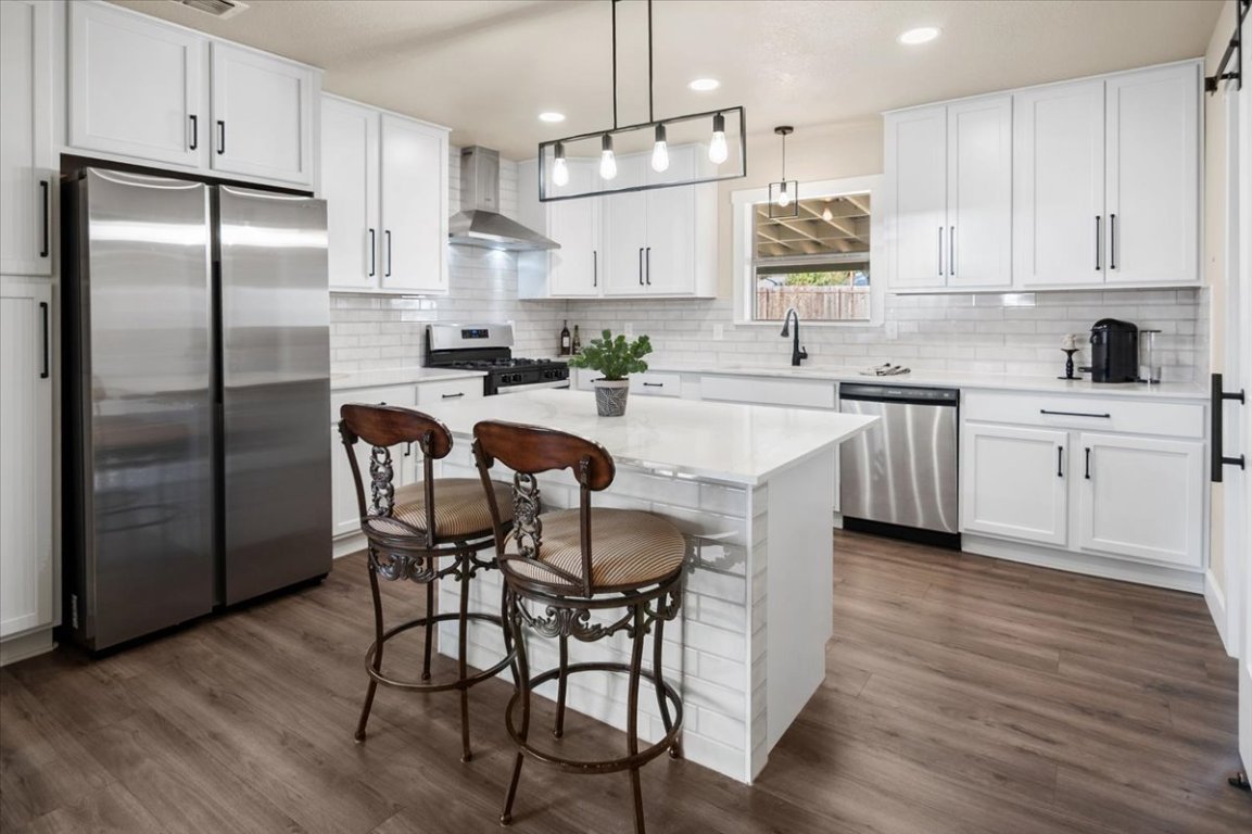 1236 Martin Street Mason, TX 76856 - Photo 9 of 40 a kitchen with stainless steel appliances granite countertop a dining table chairs refrigerator and microwave