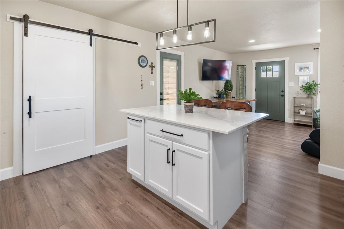 1236 Martin Street Mason, TX 76856 - Photo 10 of 40 a kitchen with kitchen island white cabinets and wooden floor