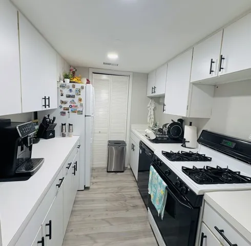 a kitchen with a stove and white cabinets