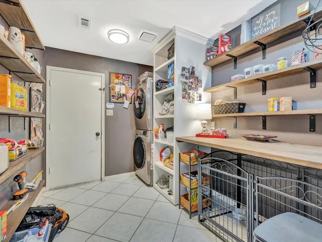 a storage utility room with lots of clutter and cabinets