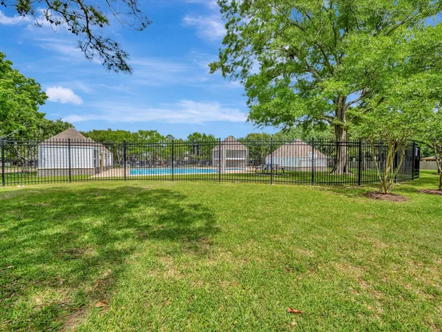 a view of yard with swimming pool and green space