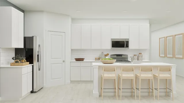 a kitchen with white cabinets and appliances