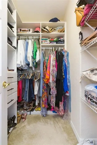 a view of walk in closet with clothes