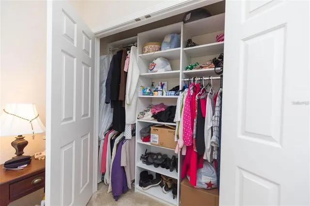 a view of walk in closet with clothes and shoes