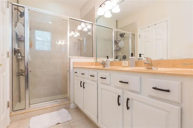 a bathroom with a shower sink vanity and mirror