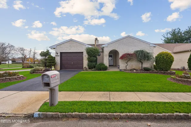a front view of a house with a garden and plants