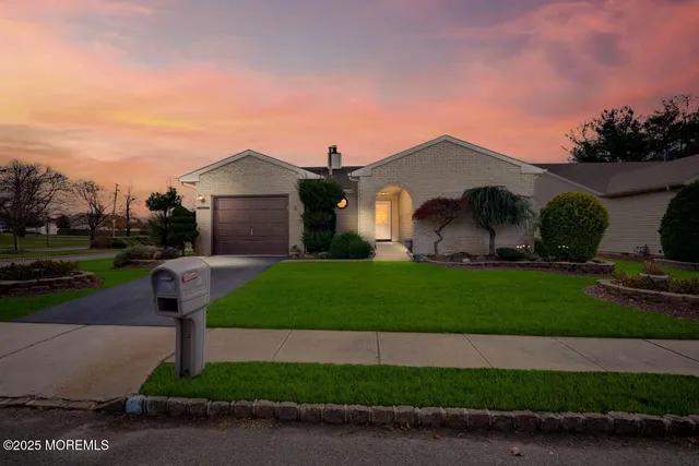 a front view of a house with a garden and yard