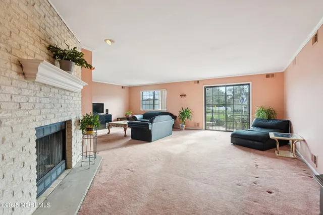 a living room with furniture a fireplace and a floor to ceiling window