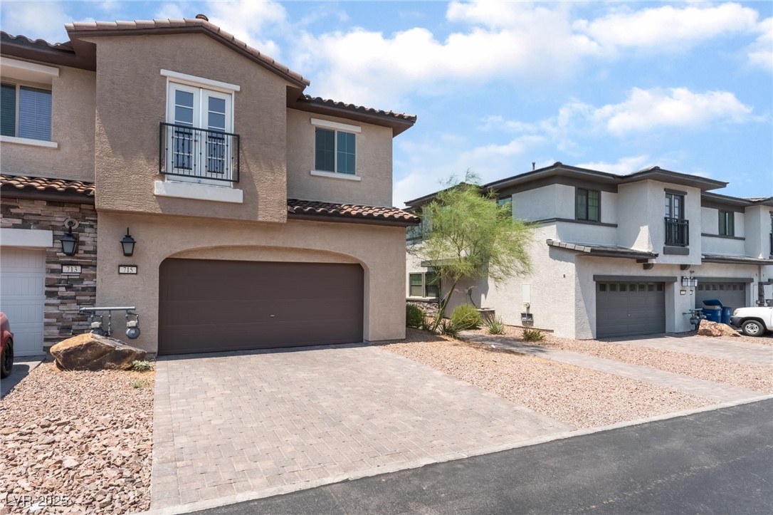 715 Pickled Pepper Place Henderson, NV 89011 - Photo 1 of 31 View of front facade featuring a balcony, stucco siding, a tile roof, decorative driveway, and an attached garage
