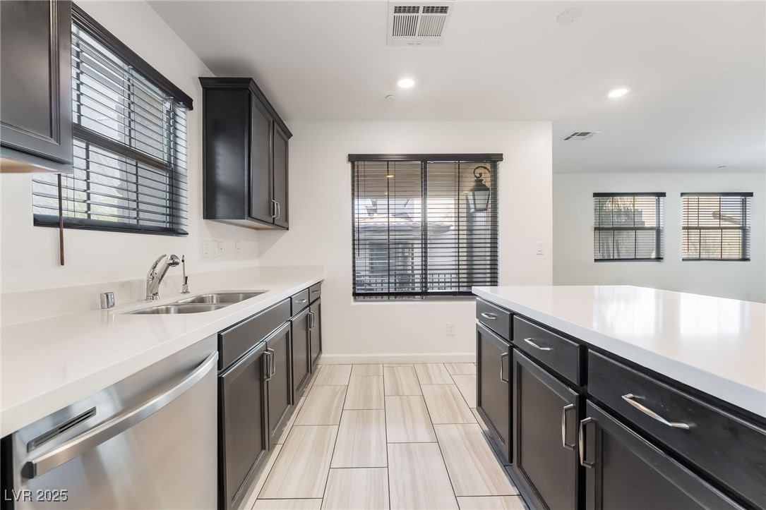 715 Pickled Pepper Place Henderson, NV 89011 - Photo 11 of 31 Kitchen with dark cabinets, dishwasher, recessed lighting, and light stone countertops