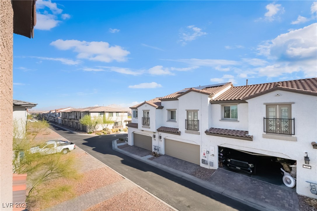 715 Pickled Pepper Place Henderson, NV 89011 - Photo 4 of 31 View of front facade with an attached garage, stucco siding, a tiled roof, and a residential view