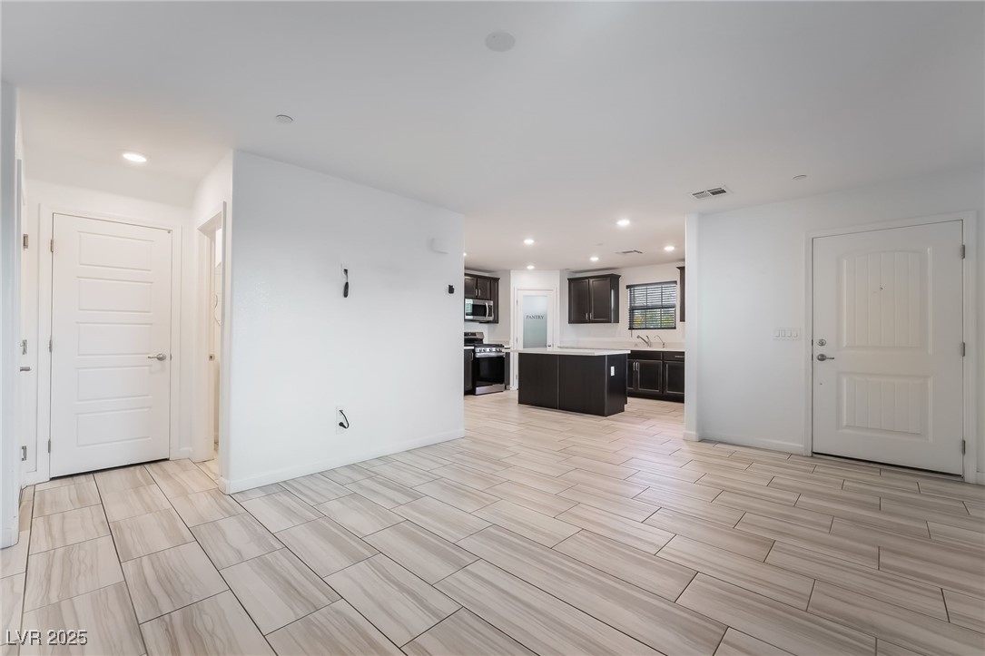 715 Pickled Pepper Place Henderson, NV 89011 - Photo 7 of 31 Unfurnished living room featuring recessed lighting and wood tiled floors