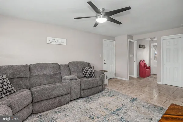 a living room with furniture and a ceiling fan