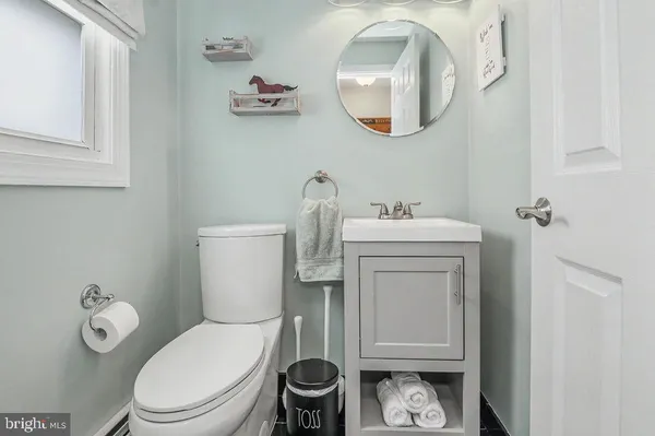 a bathroom with a toilet a sink and mirror
