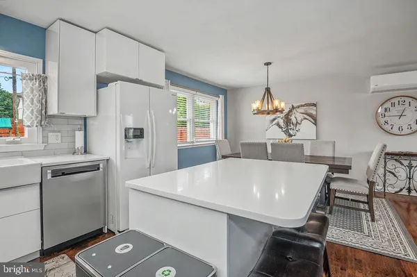 a view of kitchen with sink refrigerator dining table and chairs